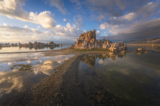 Aerial view of the unique tufa towers at Mono Lake with dramatic cloud reflections on the calm water surface and mountains in the distance Mono County California United States. Aerial view of the unique tufa towers at Mono Lake with dramatic cloud reflections on the calm water surface and mountains in the distance Mono County California United States.