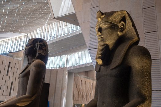 Giza Egypt 16 May 2026 View of the Grand Egyptian Museum featuring colossal ancient statues of pharaohs set against modern geometric architecture and natural light.