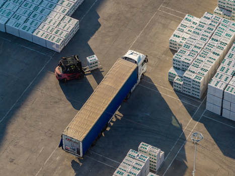 Warsaw Masovian Voivodeship Poland 14 September 2026 Aerial view of a construction site with a forklift loading building materials onto a semi trailer truck.
