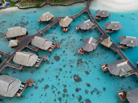 Aerial view of Sofitel Kia Ora Moorea Beach Resort with overwater bungalows over the turquoise lagoon in Moorea Maiao Windward Islands French Polynesia. Aerial view of Sofitel Kia Ora Moorea Beach Resort with overwater bungalows over the turquoise lagoon in Moorea Maiao Windward Islands French Polynesia.