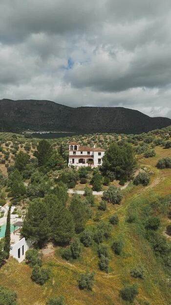 Aerial view of a white villa on a hillside in Spain.