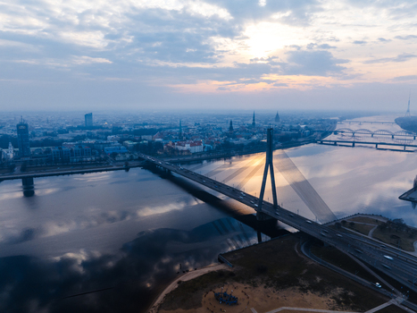 Aerial view of Vansu Bridge spanning the Daugava River with the city skyline in the background during a cloudy sunset in Riga Latvia. Aerial view of Vansu Bridge spanning the Daugava River with the city skyline in the background during a cloudy sunset in Riga Latvia.