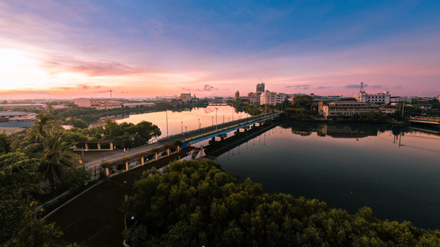 Aerial view of the bridge reflecting the pastel sky above the tranquil river embracing the buildings of the city Iloilo City Western Visayas Philippines. Aerial view of the bridge reflecting the pastel sky above the tranquil river embracing the buildings of the city Iloilo City Western Visayas Philippines.
