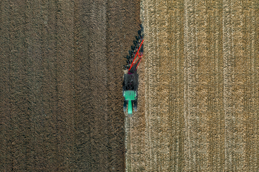 Aerial view of a tractor carving lines in the earth a contrast of dark soil and golden stubble Chyhyryns kyi district Cherkasy Oblast Ukraine. Aerial view of a tractor carving lines in the earth a contrast of dark soil and golden stubble Chyhyryns kyi district Cherkasy Oblast Ukraine.