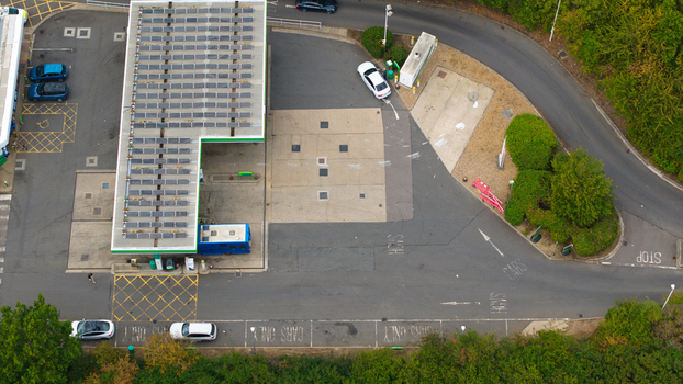 Aerial view of a gas station with solar panels on the roof and a white car parked at a pump in Bedford England United Kingdom.