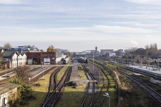 Berlin Germany 23 November 2022 View of railway tracks parked trains and industrial buildings at a train yard under a clear sky. Berlin Germany 23 November 2022 View of railway tracks parked trains and industrial buildings at a train yard under a clear sky.