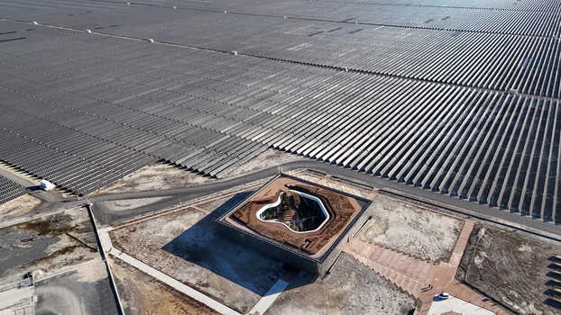 Aerial view of Karapinar Gunes Enerjisi Santrali solar power plant with vast rows of photovoltaic panels and a modern central building in Karapinar Konya Turkiye.