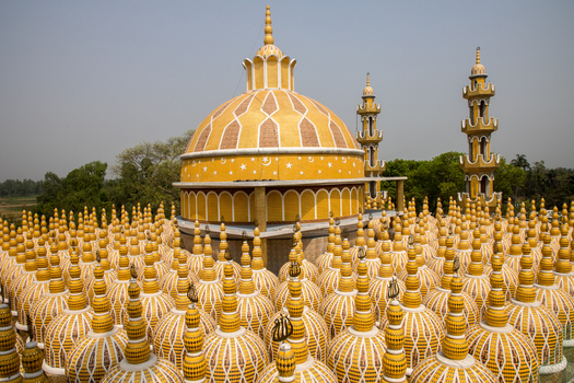 View of golden domes adorned with intricate white patterns rise majestically against the clear sky creating a surreal and captivating scene Tangail Bangladesh. View of golden domes adorned with intricate white patterns rise majestically against the clear sky creating a surreal and captivating scene Tangail Bangladesh.