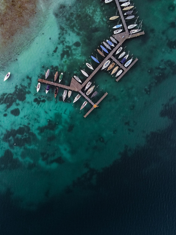 Aerial view of Attersee with numerous sailboats moored at a wooden pier in the clear turquoise water of Vocklabruck District Upper Austria Austria.