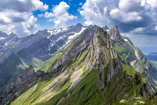Aerial view of verdant slopes meeting jagged peaks capped with snow under a vibrant sky Schwende Rüte Appenzell Innerrhoden Switzerland. Aerial view of verdant slopes meeting jagged peaks capped with snow under a vibrant sky Schwende Rüte Appenzell Innerrhoden Switzerland.