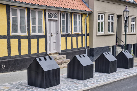 Viborg Denmark 07 August 2026 View of modern house shaped waste bins on the sidewalk in front of a traditional yellow timber framed house in the historic old town. Viborg Denmark 07 August 2026 View of modern house shaped waste bins on the sidewalk in front of a traditional yellow timber framed house in the historic old town.