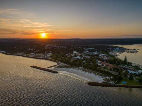 Aerial view of Emu Point featuring the sandy beach breakwaters and marina illuminated by the warm golden light of the setting sun in Emu Point Western Australia Australia. Aerial view of Emu Point featuring the sandy beach breakwaters and marina illuminated by the warm golden light of the setting sun in Emu Point Western Australia Australia.