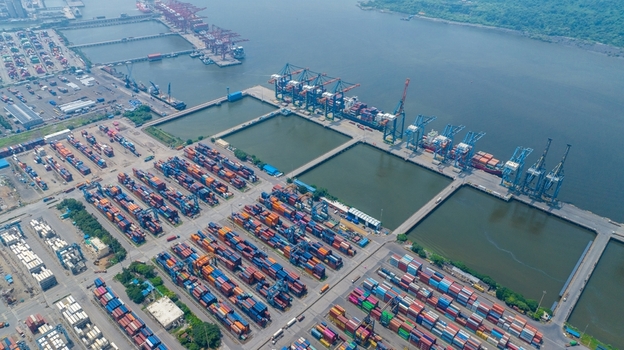 Aerial view of Jawaharlal Nehru Port Authority with rows of colorful shipping containers large gantry cranes and cargo ships docked at the harbor in Juna Sheva Maharashtra India. Aerial view of Jawaharlal Nehru Port Authority with rows of colorful shipping containers large gantry cranes and cargo ships docked at the harbor in Juna Sheva Maharashtra India.
