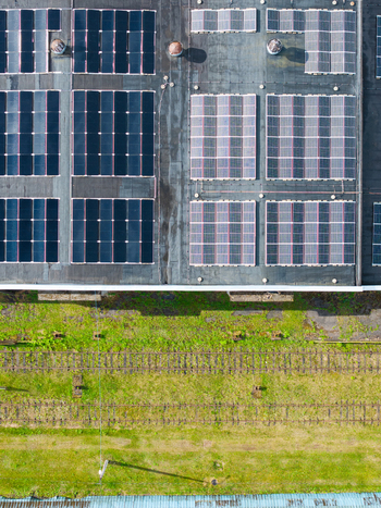 Aerial view of a large industrial rooftop covered with numerous solar panels situated next to railway tracks and green grass in Olaine Olaine Municipality Latvia. Aerial view of a large industrial rooftop covered with numerous solar panels situated next to railway tracks and green grass in Olaine Olaine Municipality Latvia.