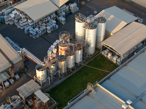 Kilsyth VIC Australia 22 September 2026 Aerial view of an industrial facility with large metal storage tanks warehouses with corrugated roofs and rows of containers under afternoon light. Kilsyth VIC Australia 22 September 2026 Aerial view of an industrial facility with large metal storage tanks warehouses with corrugated roofs and rows of containers under afternoon light.
