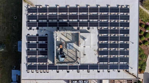 Aerial view of solar panels installed on a flat commercial rooftop in Boulder Colorado United States. Aerial view of solar panels installed on a flat commercial rooftop in Boulder Colorado United States.