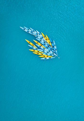 Aerial view of a group of yellow and blue kayaks floating in the clear turquoise water of Vietnam. Aerial view of a group of yellow and blue kayaks floating in the clear turquoise water of Vietnam.