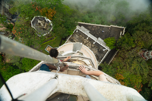 View of people climbing the narrow spiral staircase of Ambuluwawa Tower overlooking lush green forests and misty mountains in Gampola Central Province Sri Lanka. View of people climbing the narrow spiral staircase of Ambuluwawa Tower overlooking lush green forests and misty mountains in Gampola Central Province Sri Lanka.