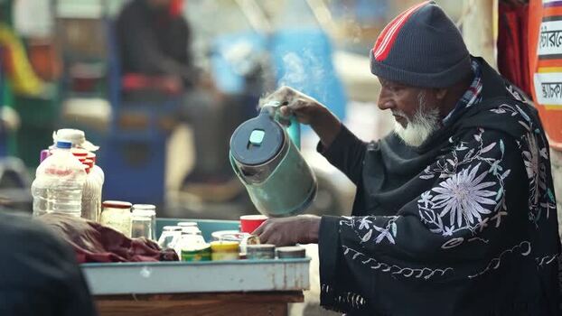 View of a man pouring tea at a street stall in Bogura Bangladesh.