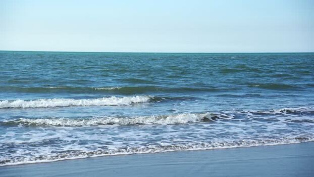 View of ocean waves crashing on the sandy beach Bangladesh.