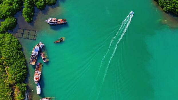 Aerial view of a boat cruising in turquoise water Honduras.
