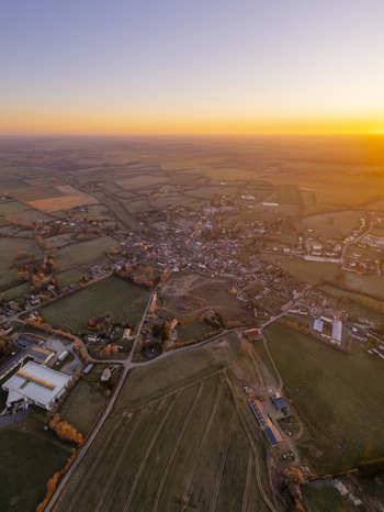 Aerial view of the village of Sap en Auge surrounded by rural fields and roads in the golden hour light in Sap en Auge Normandy France. Aerial view of the village of Sap en Auge surrounded by rural fields and roads in the golden hour light in Sap en Auge Normandy France.