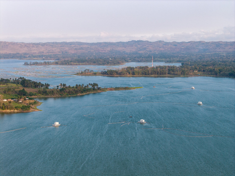 Aerial view of Sutami Dam in Karangkates featuring floating fish farms on the reservoir surrounded by lush hills in Kecamatan Sumberpucung Jawa Timur Indonesia. Aerial view of Sutami Dam in Karangkates featuring floating fish farms on the reservoir surrounded by lush hills in Kecamatan Sumberpucung Jawa Timur Indonesia.
