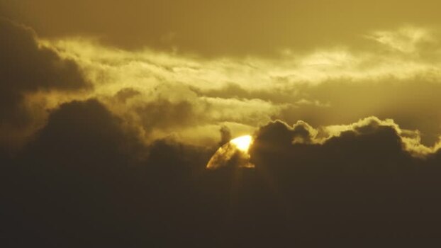 Aerial view of the sun setting behind dark clouds in Algeria.
