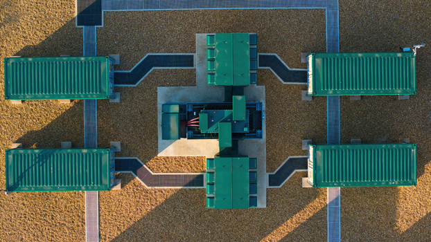 Aerial view of the Battery Energy park BESS Grendon featuring green storage containers and electrical infrastructure on a gravel site in Northampton England United Kingdom. Aerial view of the Battery Energy park BESS Grendon featuring green storage containers and electrical infrastructure on a gravel site in Northampton England United Kingdom.