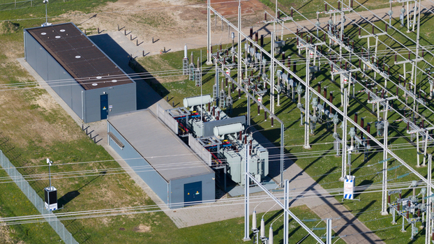 Aerial view of an electrical substation with large transformers metal power line structures and industrial buildings on a green field Zwolle Overijssel Netherlands. Aerial view of an electrical substation with large transformers metal power line structures and industrial buildings on a green field Zwolle Overijssel Netherlands.