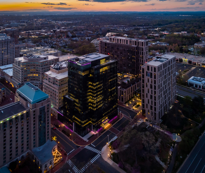 Reston United States 12 April 2020 Aerial view of modern office buildings and urban infrastructure in Reston Town Center at dusk with glowing windows.