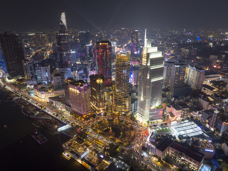 Aerial view of the illuminated skyline of Ho Chi Minh City at night with Bitexco Financial Tower and glowing skyscrapers overlooking the riverfront Ho Chi Minh City Ho Chi Minh Vietnam. Aerial view of the illuminated skyline of Ho Chi Minh City at night with Bitexco Financial Tower and glowing skyscrapers overlooking the riverfront Ho Chi Minh City Ho Chi Minh Vietnam.