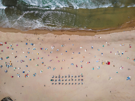 Aerial view of Praia de Odeceixe with people on the beach in summertime with Atlantic Ocean rough sea in background Odeceixe Faro Portugal.