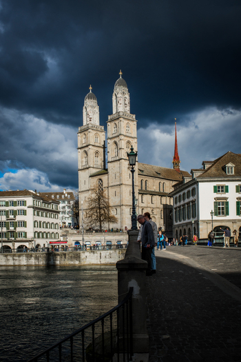 Zurich Switzerland 02 April 2023 View of the Grossmünster church under a dramatic brooding sky its twin towers a beacon against the gathering storm reflected in the dark waters below. Zurich Switzerland 02 April 2023 View of the Grossmünster church under a dramatic brooding sky its twin towers a beacon against the gathering storm reflected in the dark waters below.