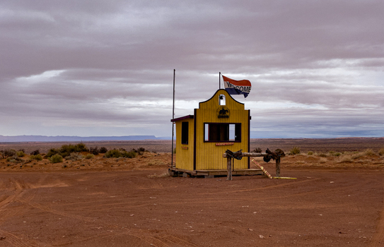 View of a yellow wooden booth at the entrance to Monument Valley Tribal Park under a cloudy sky in Oljato Monument Valley Utah United States.