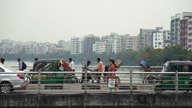 View of rickshaws and commuters on a bridge in Dhaka Bangladesh.