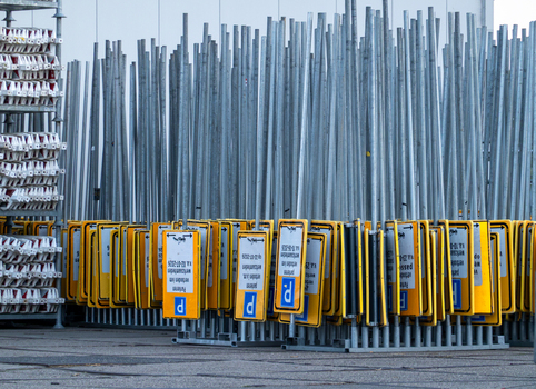 View of a large collection of yellow parking signs with blue P symbols mounted on metal poles stored in a depot in Zaandam North Holland Netherlands.