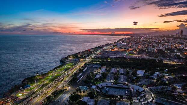 Aerial view of Feria Ganadera and the coastal skyline of Santo Domingo at sunset with illuminated roads and the Caribbean Sea in Santo Domingo Distrito Nacional Dominican Republic. Aerial view of Feria Ganadera and the coastal skyline of Santo Domingo at sunset with illuminated roads and the Caribbean Sea in Santo Domingo Distrito Nacional Dominican Republic.