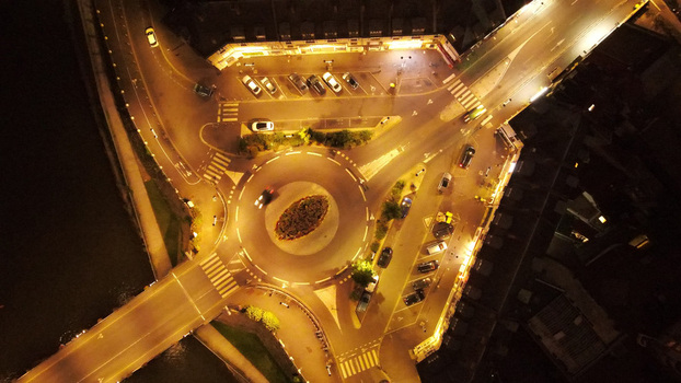 Aerial view of a roundabout illuminated at night with surrounding streets parked cars and urban infrastructure in Pontoise Ile de France France. Aerial view of a roundabout illuminated at night with surrounding streets parked cars and urban infrastructure in Pontoise Ile de France France.