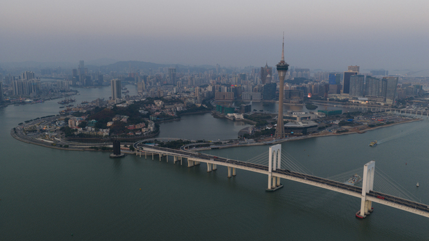 Macao 18 February 2026 Aerial view of Macau Tower and Sai Van Bridge spanning the water with the urban skyline and coastal landscape of Macau under a soft evening sky. Macao 18 February 2026 Aerial view of Macau Tower and Sai Van Bridge spanning the water with the urban skyline and coastal landscape of Macau under a soft evening sky.