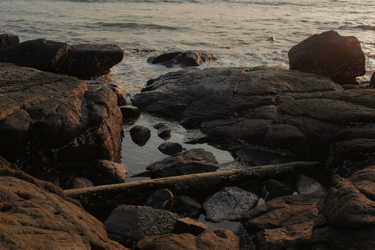 View of sun kissed rocks meet the gentle waves in a serene coastal landscape the tranquil water reflecting the sky Chiplun Maharashtra India. View of sun kissed rocks meet the gentle waves in a serene coastal landscape the tranquil water reflecting the sky Chiplun Maharashtra India.