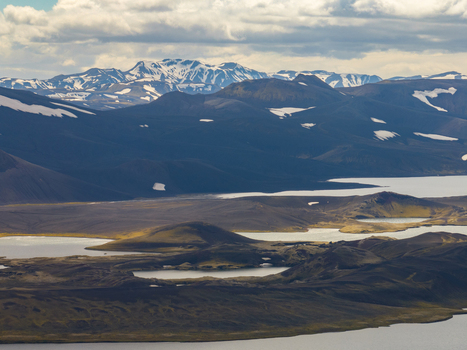 Aerial view of volcanic landscape with glacial lakes and snow capped mountains under a cloudy sky Iceland. Aerial view of volcanic landscape with glacial lakes and snow capped mountains under a cloudy sky Iceland.