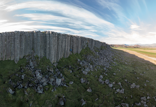 Aerial view of the basalt columns of Gerduberg Cliffs with green vegetation and rocky debris under a blue sky in Raudhamelur Eyja og Miklaholtshr Iceland. Aerial view of the basalt columns of Gerduberg Cliffs with green vegetation and rocky debris under a blue sky in Raudhamelur Eyja og Miklaholtshr Iceland.