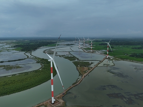 Aerial view of the Khurushkul wind power project with red and white turbines standing in the wetlands near the river in Cox s Bazar Chittagong Division Bangladesh. Aerial view of the Khurushkul wind power project with red and white turbines standing in the wetlands near the river in Cox s Bazar Chittagong Division Bangladesh.