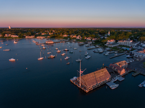 View of Martha s Vineyard harbor with numerous boats moored in the calm water during a colorful sunset in Edgartown Massachusetts United States.