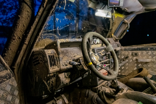 View of the mud covered interior of an off road vehicle featuring a steering wheel and metal floor panels in Sortavala Respublika Kareliya Russia.