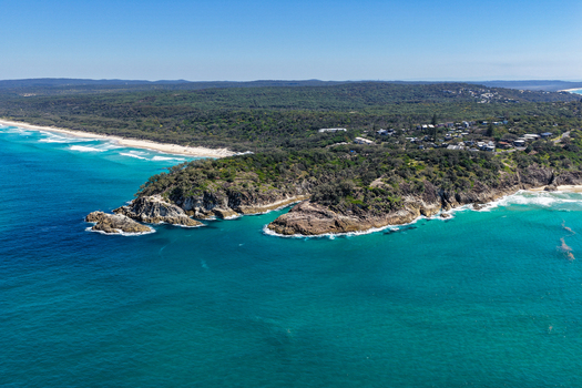 Aerial view of North Stradbroke Island featuring rocky headlands turquoise ocean waters sandy beaches and coastal vegetation in Redland City Queensland Australia. Aerial view of North Stradbroke Island featuring rocky headlands turquoise ocean waters sandy beaches and coastal vegetation in Redland City Queensland Australia.