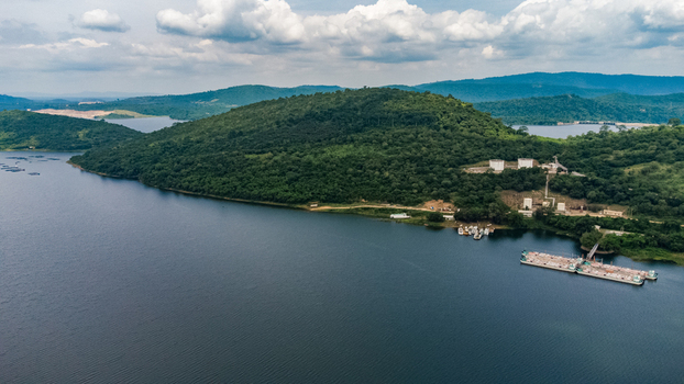 Aerial view of Akosombo Port on the shores of Lake Volta featuring lush green hills calm water and small boats docked at the pier in Akosombo Eastern Region Ghana. Aerial view of Akosombo Port on the shores of Lake Volta featuring lush green hills calm water and small boats docked at the pier in Akosombo Eastern Region Ghana.