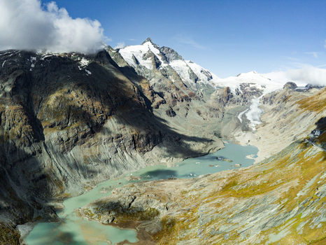 Aerial view of the Grossglockner High Alpine Road winding through the alpine landscape with the Pasterze glacier and a glacial lake in Zell am See District Salzburg Austria.