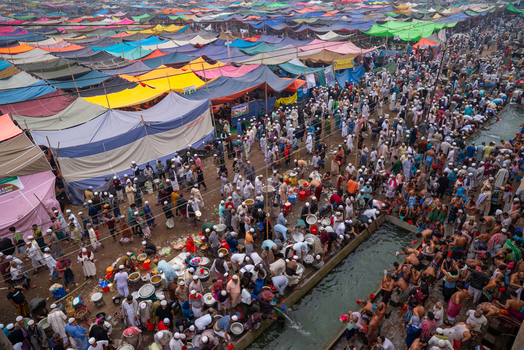 Tongi Dhaka Division Bangladesh 31 January 2025 Aerial view of the Bishwa Ijtema at Tongi Ijtema Maidan with colorful tents and crowds of people near a water channel.